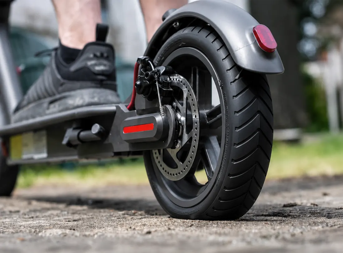 Fahrer startet mit frisch repariertem E-Scooter und neuem Reifen auf der Straße