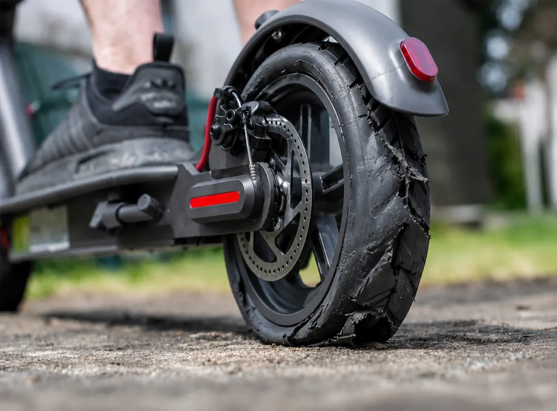 Xiaomi M365 E-Scooter mit plattem, abgefahrenem Reifen vor der Reparatur bei E-Scooter Nord in Kiel
